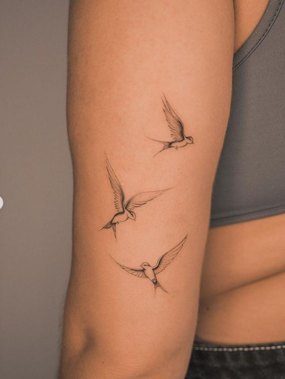 a woman's arm with three birds on it