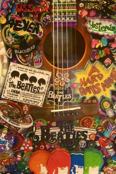 an acoustic guitar covered in stickers and decals