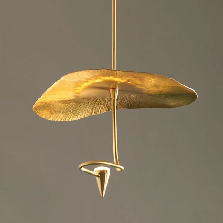 a gold leaf hanging from a hook in the air