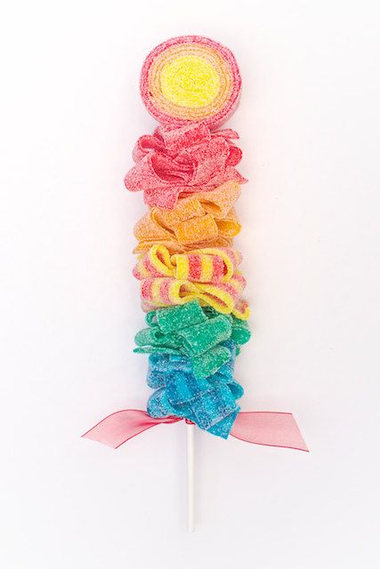 the lollipop is made out of multicolored yarn and has a pink ribbon