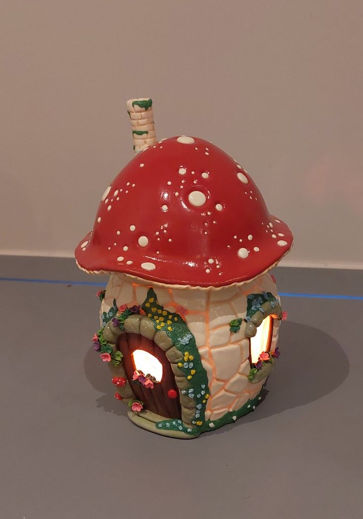 a ceramic mushroom house with a lit candle inside