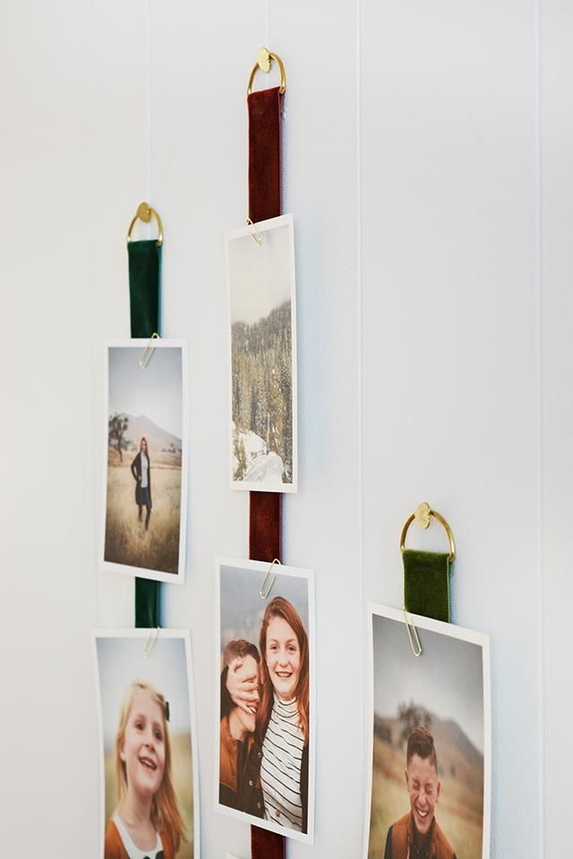 several photos hanging on a wall with clips attached to them