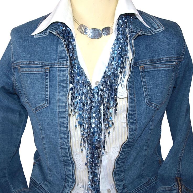 a woman wearing a denim jacket with blue beads on the collar and white shirt underneath