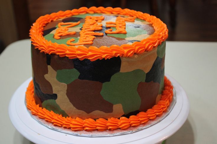 a camouflage cake with orange frosting on a table