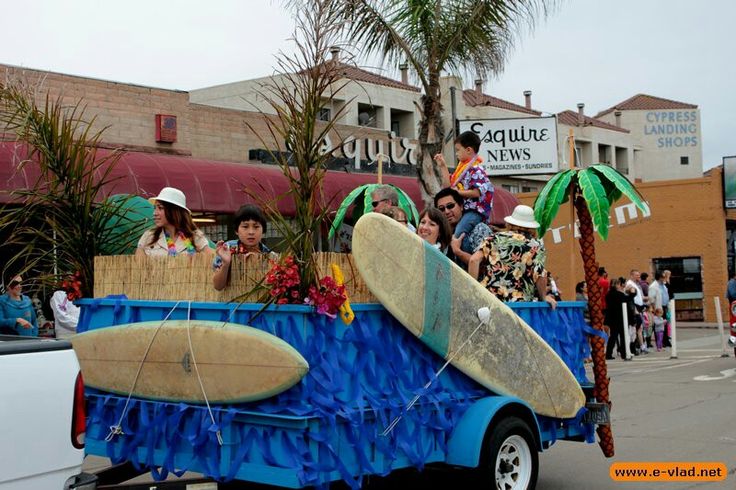 people riding in the back of a blue truck with surfboards on it's flat bed