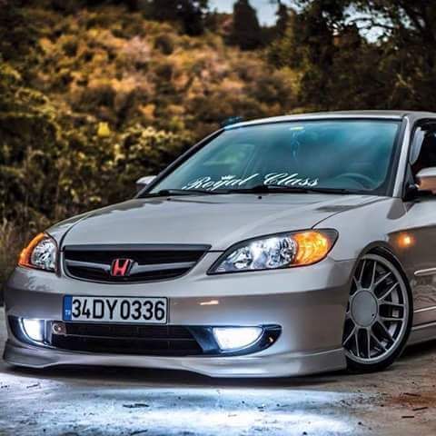 a silver car parked in front of some trees