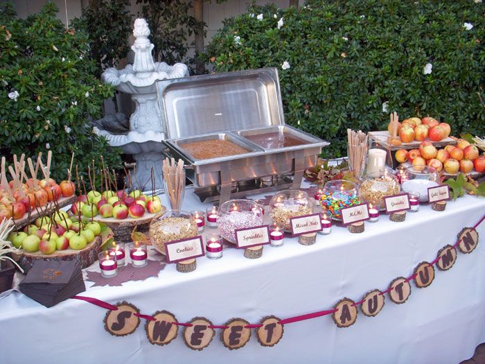 an outdoor buffet with apples and desserts on it