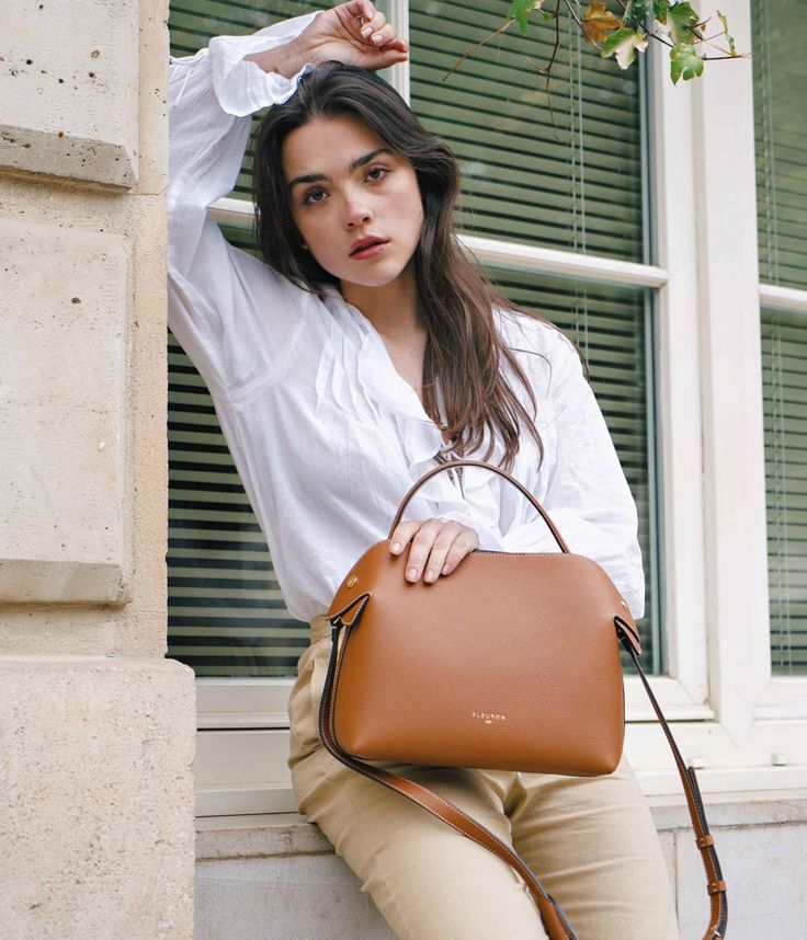 Savor the bittersweet elegance of our Fleuron bag in caramel color. This warm and versatile shade complements any outfit perfectly. Made in Italy from grained calf leather, this bag features a beige interior and golden details for a luxurious finish. Timeless Outfits, Raw Jeans, Gold Models, Scarf Headband, Caramel Color, Metal Accessories, Leather Care, Coach Dinky Crossbody, Calf Leather