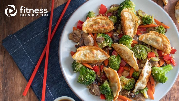 a white plate topped with meat and veggies next to chopsticks