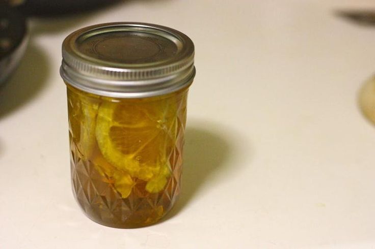 a mason jar filled with sliced lemons on top of a counter