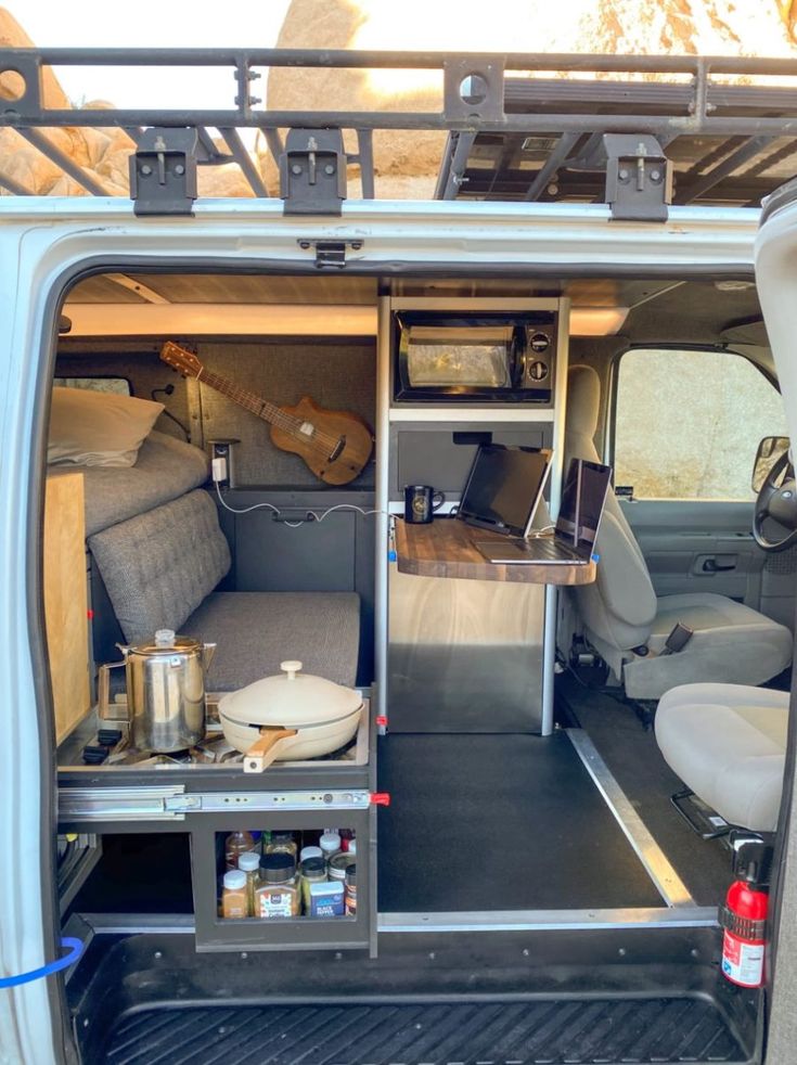 the back end of a van with its door open and shelves full of items in it