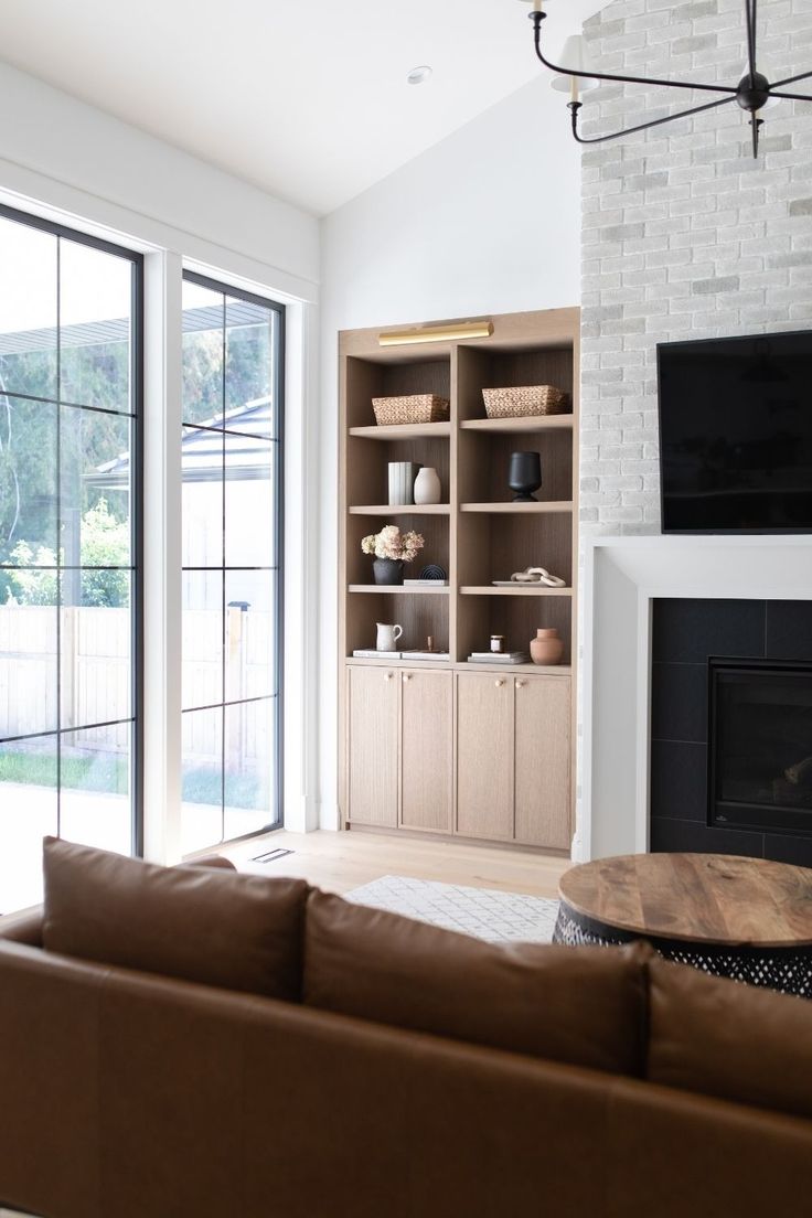 a living room filled with furniture and a flat screen tv mounted on a wall above a fireplace