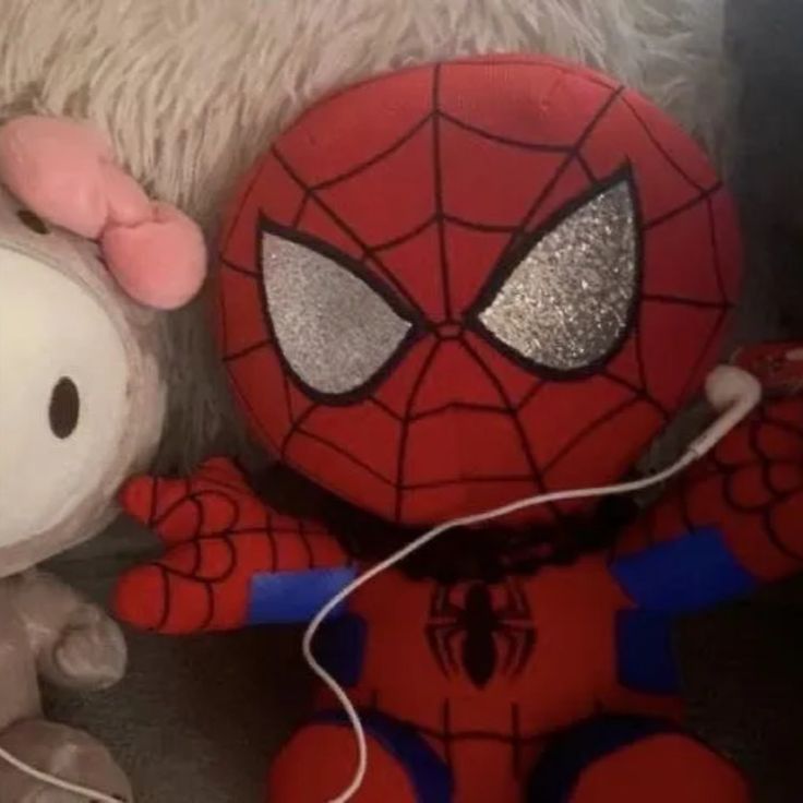 hello kitty and spider - man stuffed animals are sitting next to each other