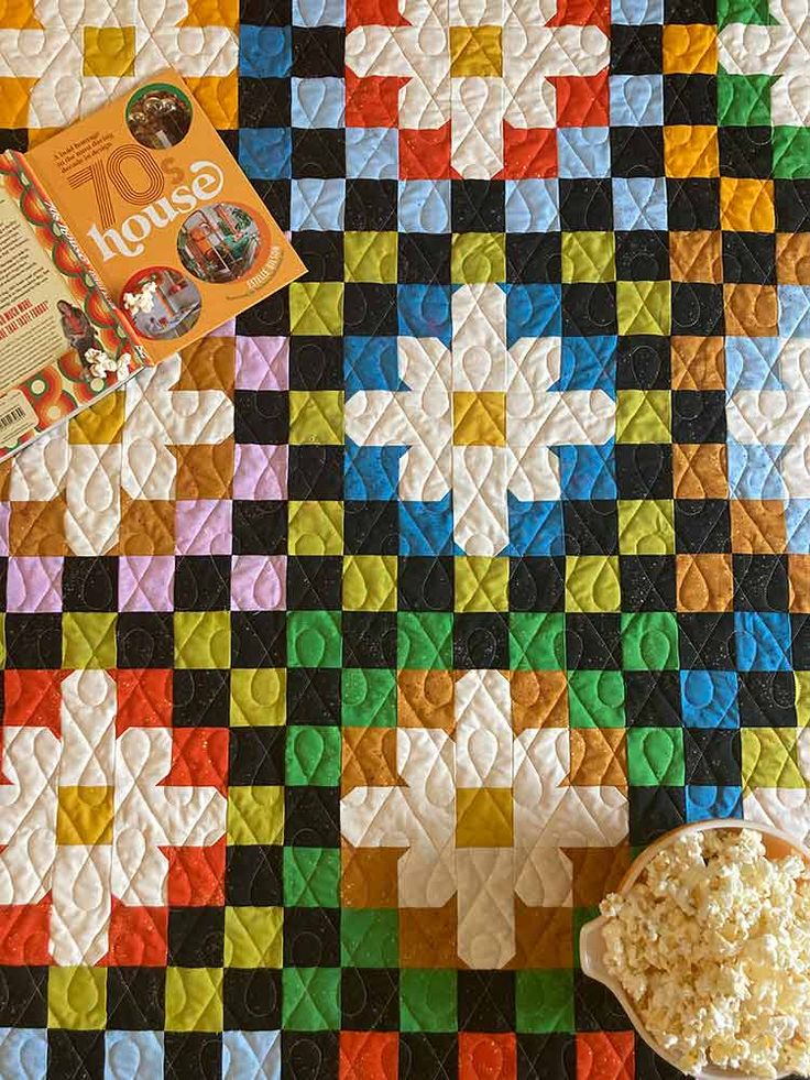 a quilted table top with a bowl of popcorn and a book on the side