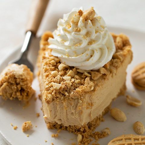 a piece of pie with whipped cream on top and cookies around the edges, sitting on a white plate