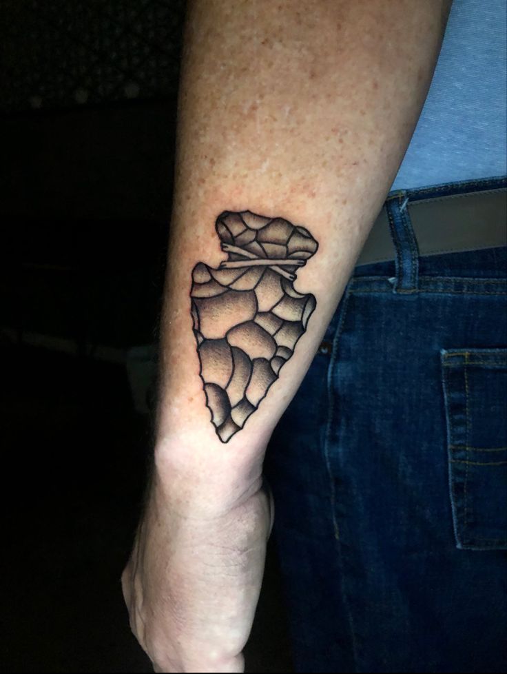 a man's arm with a tattoo on it that shows the shape of a mountain