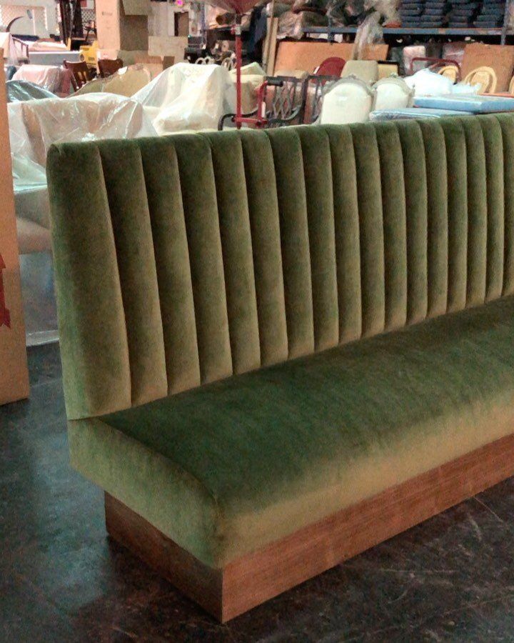 a green couch sitting on top of a wooden table