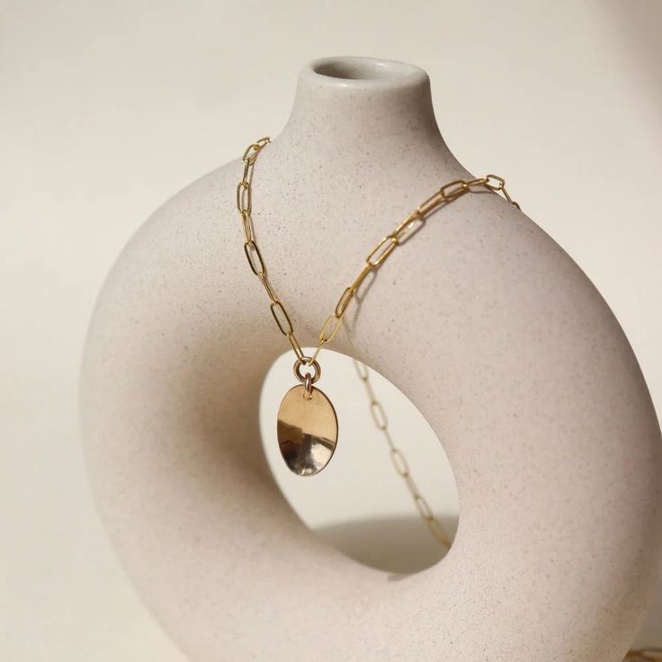 DescriptionThe Olivia Necklace features: Hypoallergenic, waterproof, and nickel free Simple and versatile Minimalistic look Made in the USA Size14" chain, pendant measures 0.8". Material14k gold fill About Token JewelryModern + minimal jewelry with a timeless feel, founded in 2005 by Sarah Willger. Each piece of Token Jewelry is handmade from start to finish, using sterling silver, 14k yellow and rose gold fill and natural gemstones. Sarah draws inspiration for her designs through the exploratio Gold Modern Charm Necklace For Everyday, Modern Gold Charm Necklace For Everyday, Minimalist Silver Charm Necklace With Gold Chain, Gold Oval Pendant Charm Necklace In Brass, Gold Oval Pendant Brass Charm Necklace, Modern Brass Necklace With Delicate Chain, Gold Brass Oval Pendant Charm Necklace, Minimalist Round Brass Chain Necklace, Gold Chain Necklace With Tarnish Resistant Oval Pendant