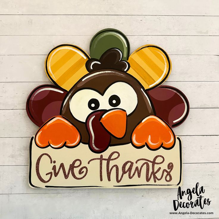 a turkey holding a sign that says give thanks with the words thanksgiving written on it