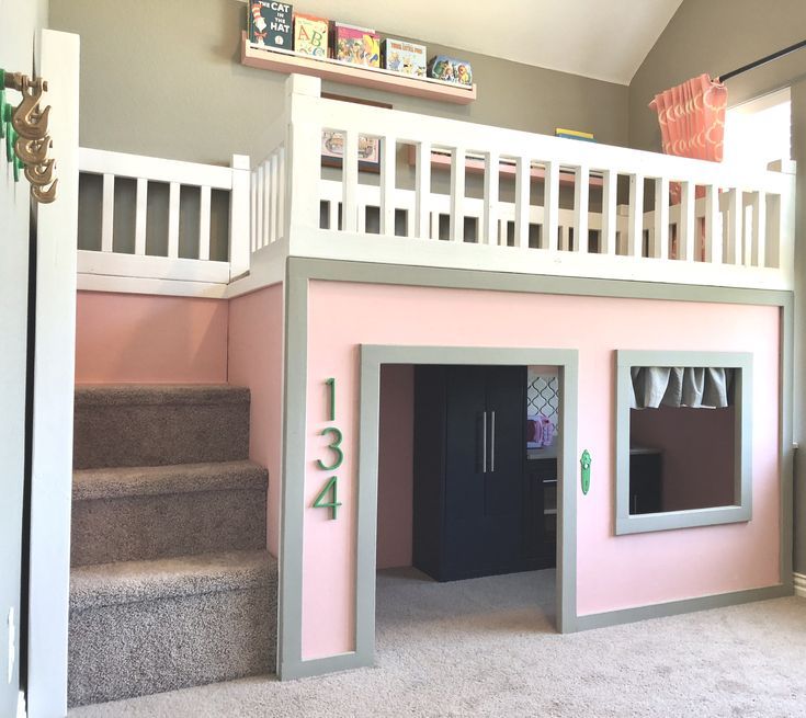 the inside of a doll house with stairs and pink walls, carpeted flooring