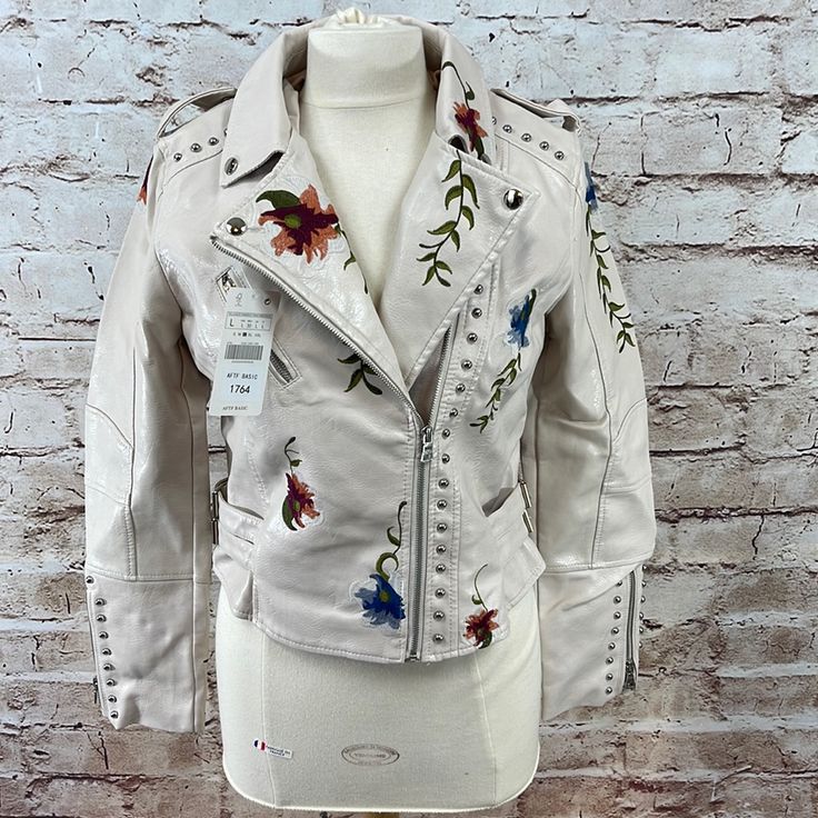 New With Tags. Embroidered And Studded Ivory Vegan Leather. 15” Across Shoulders 18 1/2” Across Chest 23 1/2 Sleeve Length 18 1/2” Center Back Length Adjustable Waist Straps. Casual White Biker Jacket For Spring, Casual White Biker Jacket For Fall, Fitted Leather Jacket With Floral Embroidery For Winter, Fall Beige Outerwear With Floral Embroidery, Winter Floral Embroidered Fitted Leather Jacket, Winter Beige Outerwear With Floral Print, Beige Floral Embroidered Outerwear For Fall, Beige Floral Print Outerwear For Winter, Winter Beige Floral Print Outerwear