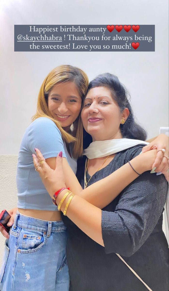 two women hugging each other in front of a birthday card