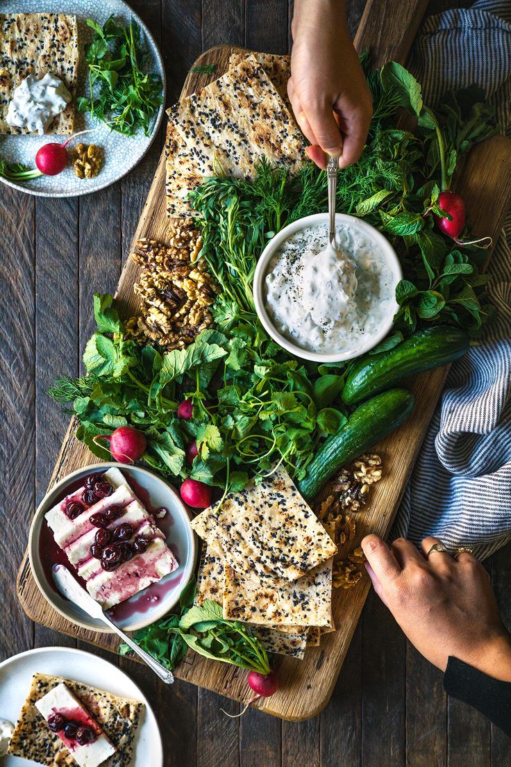 a person is eating food on a wooden board with other plates and bowls next to it