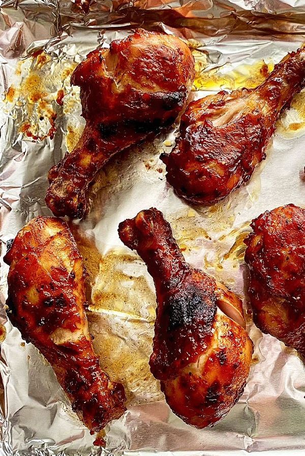 chicken wings on tin foil in an oven ready to be cooked and put into the oven