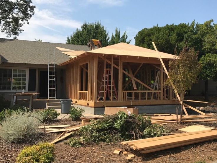 a house being built with wooden framing and roof trusses on the front of it