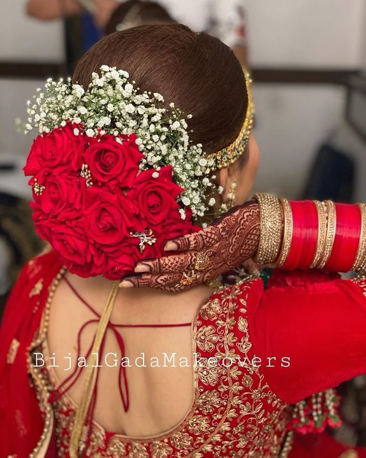 the back of a woman's head with flowers in her hair and red dress