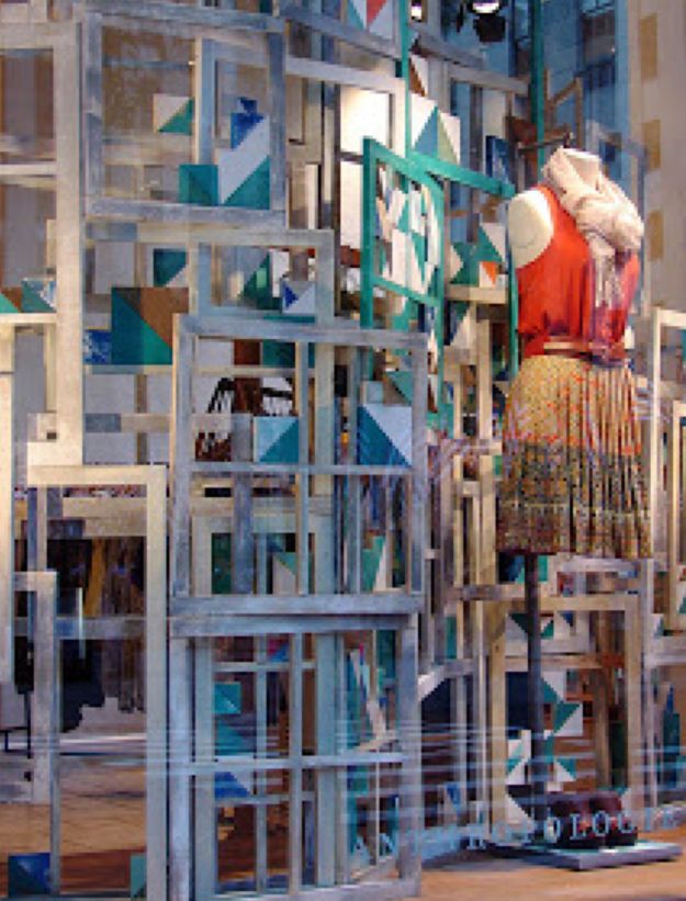 the mannequin is surrounded by multiple pieces of wood and glass, all in different colors