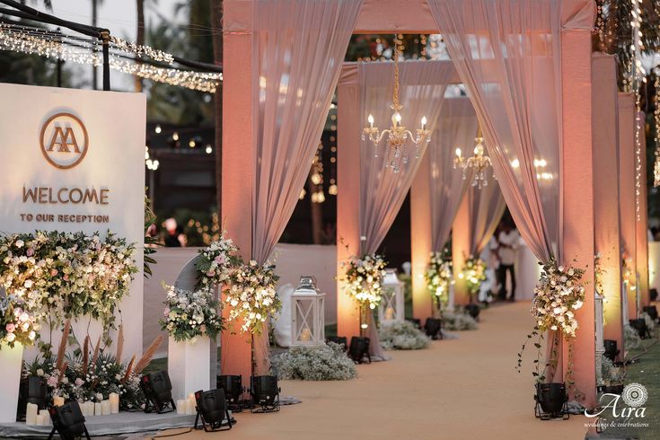 the entrance to an event decorated with flowers and lights