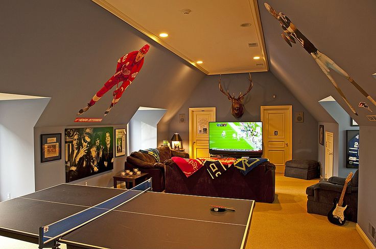 a living room filled with furniture and a ping pong table in front of a flat screen tv