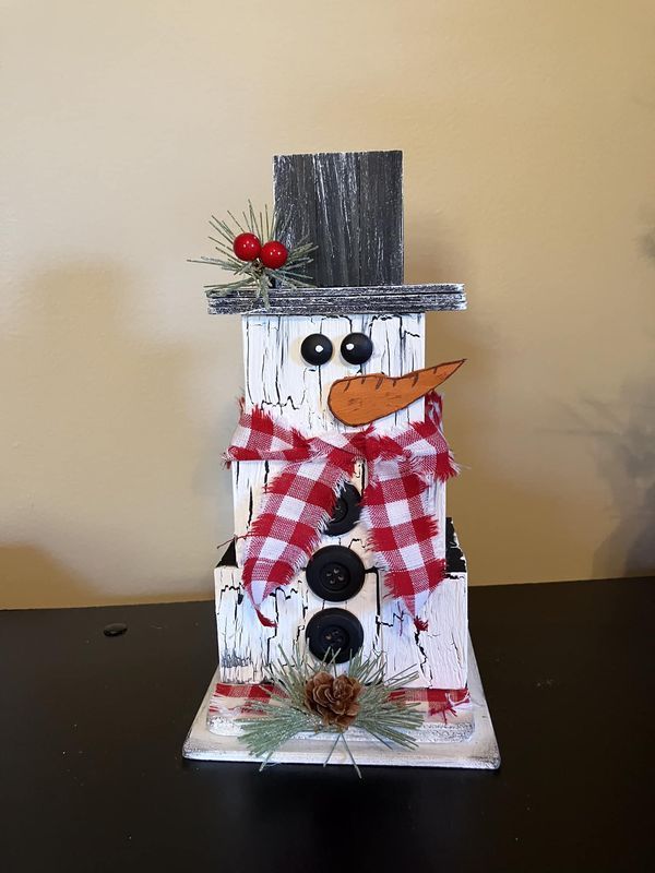 a snowman made out of wood sitting on top of a table