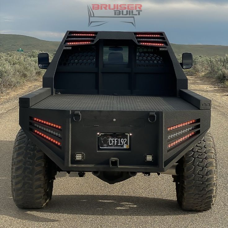 the back end of a black truck with red lights on it's tail lights