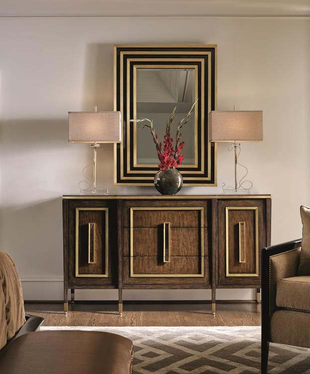 a living room scene with focus on the sideboard and lamp's in the background