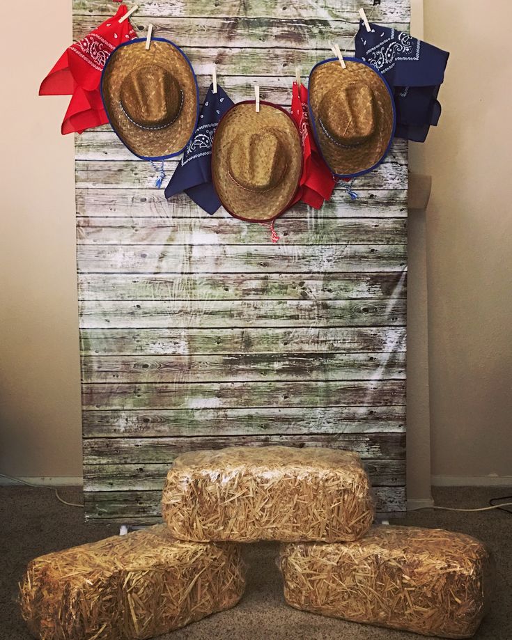 three straw bales stacked on top of each other in front of a cowboy hat display