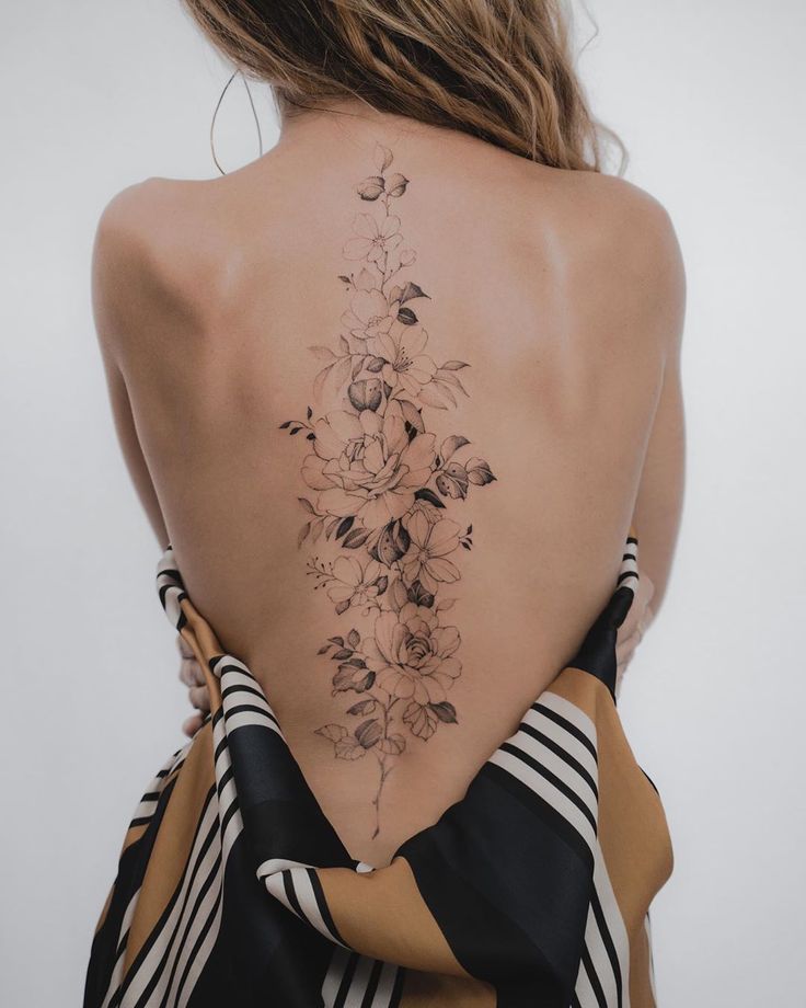 the back of a woman's body with flowers on her upper and lower back