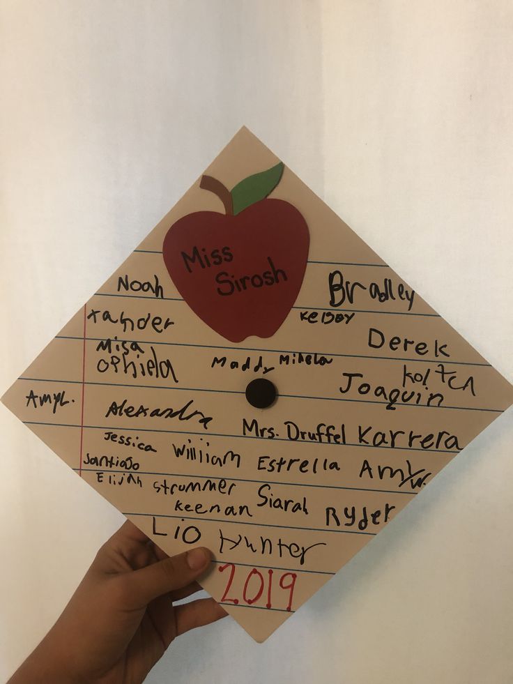 a hand holding up a piece of paper that has an apple on it with writing underneath