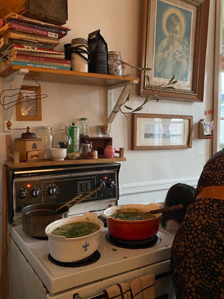 a stove top oven sitting next to a wall with pictures on the wall above it