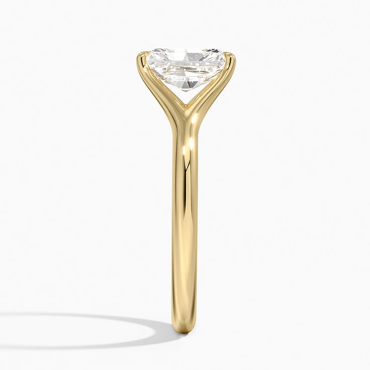 a yellow gold ring with an oval cut diamond