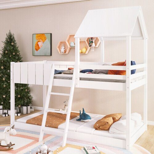 a white bunk bed sitting next to a christmas tree in a room with toys on the floor