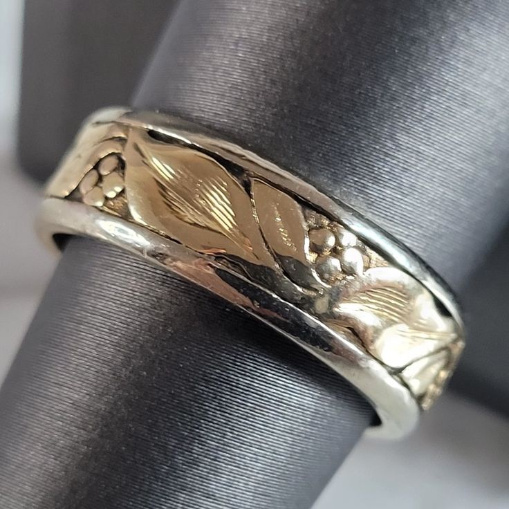 a close up of a wedding ring on a cloth covered napkin with flowers and leaves