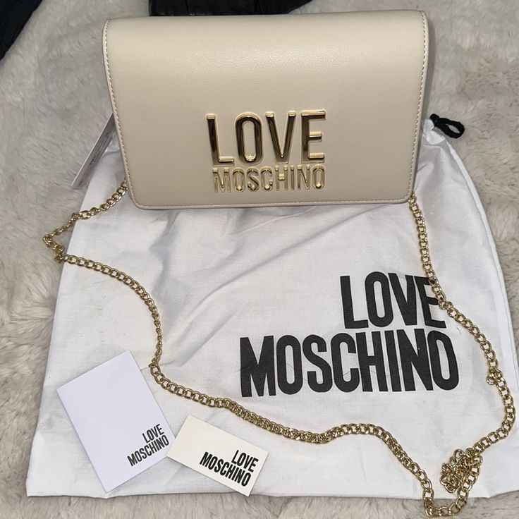 New Crossbody Bag By Moschino, Great Size For Daily Use Or For Your Classy Dining Out, Gold Hardware, With Dustbag, Dimension Is 8.5” X 6” X 1.5” Logo Satchel Bags For Evening, Evening Satchel Bags With Logo, Luxury Clutch Bag With Logo, Elegant Pouch Bag With Logo, Elegant Logo Pouch Bag, Beige Logo Crossbody Bag, Love Moschino Bag Outfit, White Crossbody Box Bag With Gold-tone Hardware, Moschino Heart Bag