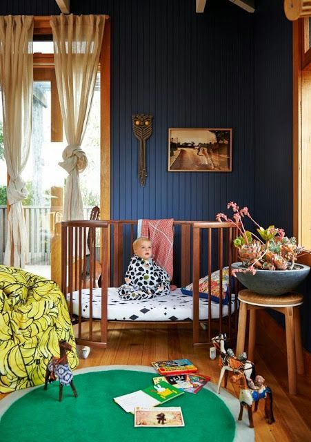 a child's room with blue walls and wooden floors, including a crib