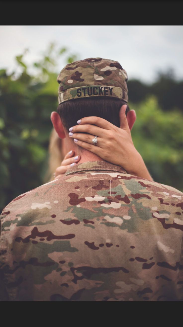 a soldier holding his hand on the back of another soldier's head while they are hugging each other