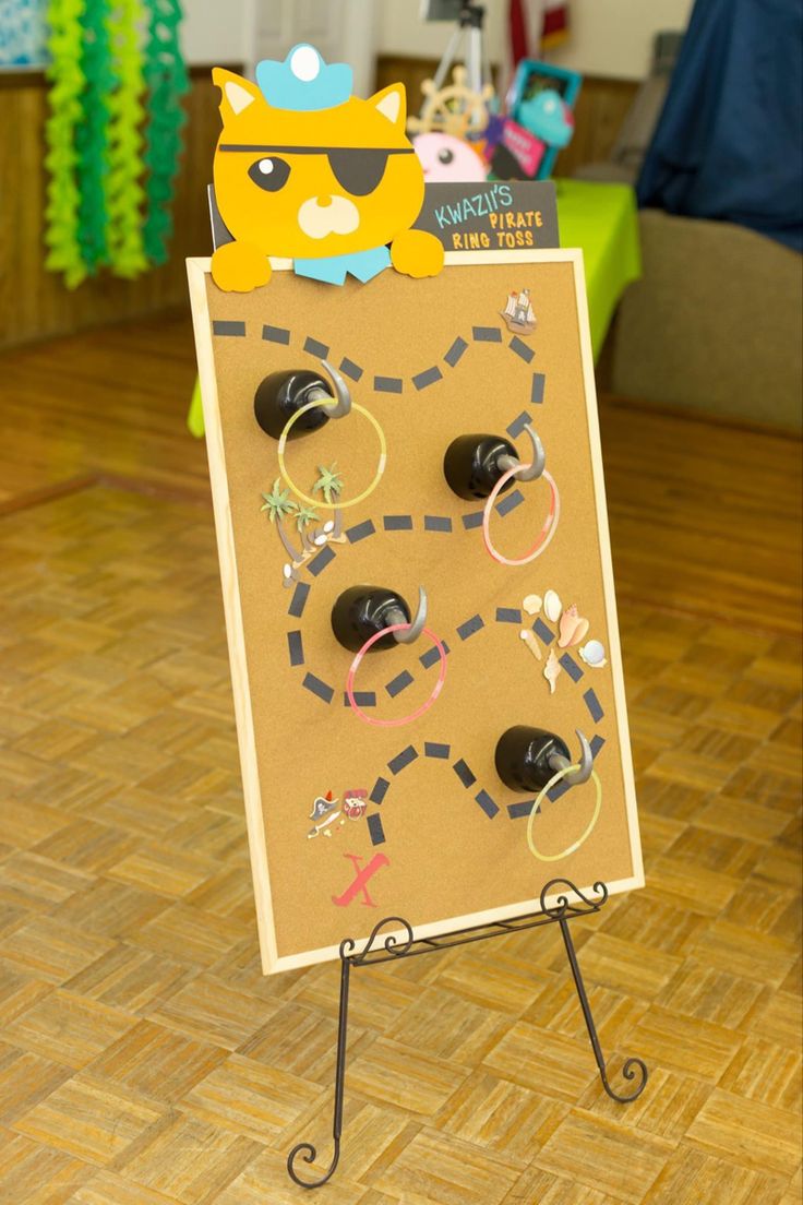 a cardboard board with rings on it in the middle of a wooden floored room