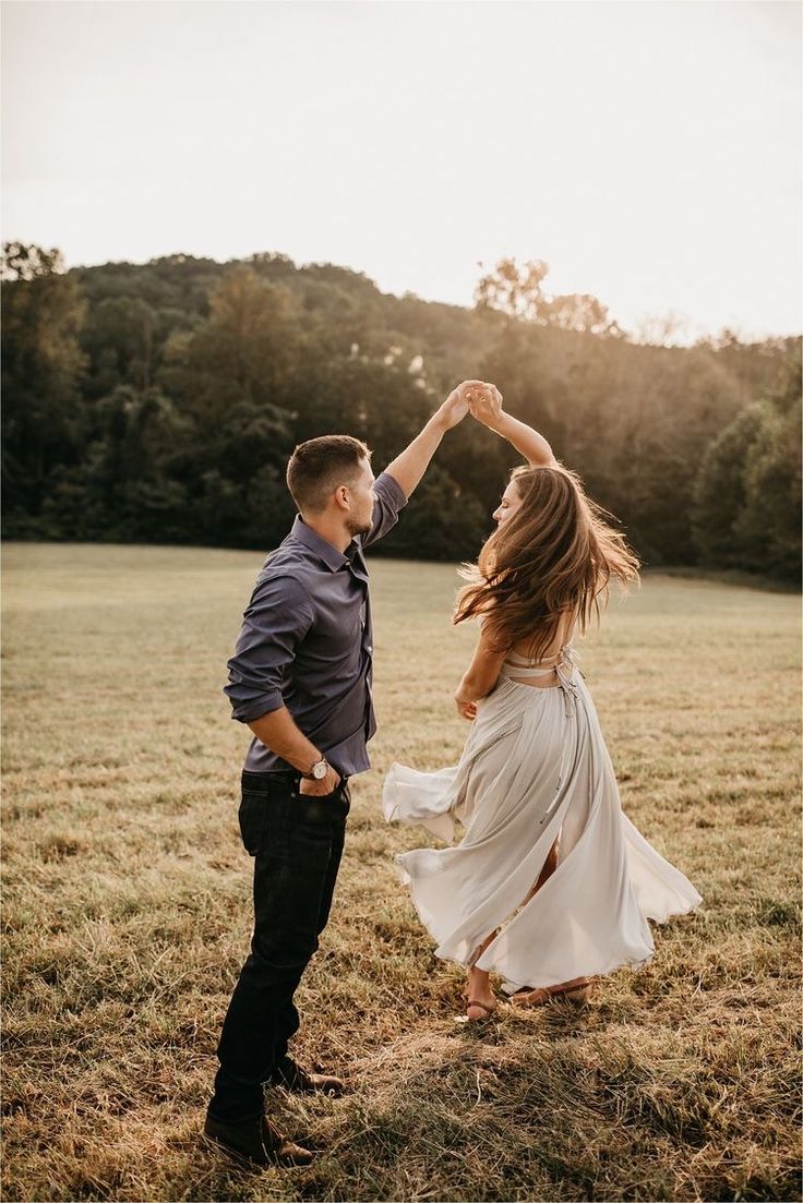 a man and woman dancing in a field