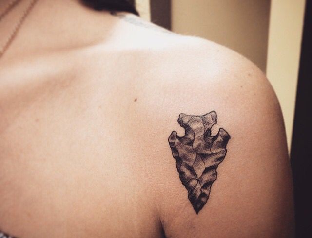 a woman with a tattoo on her shoulder that is shaped like a leaf and has leaves in the shape of a heart