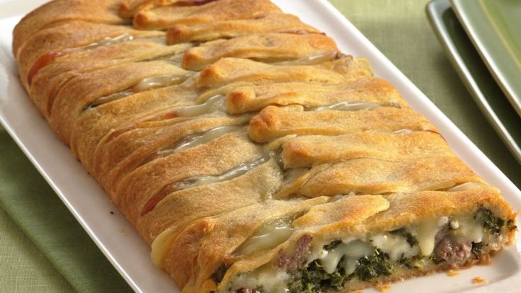 a white plate topped with a cheesy pastry on top of a green table cloth